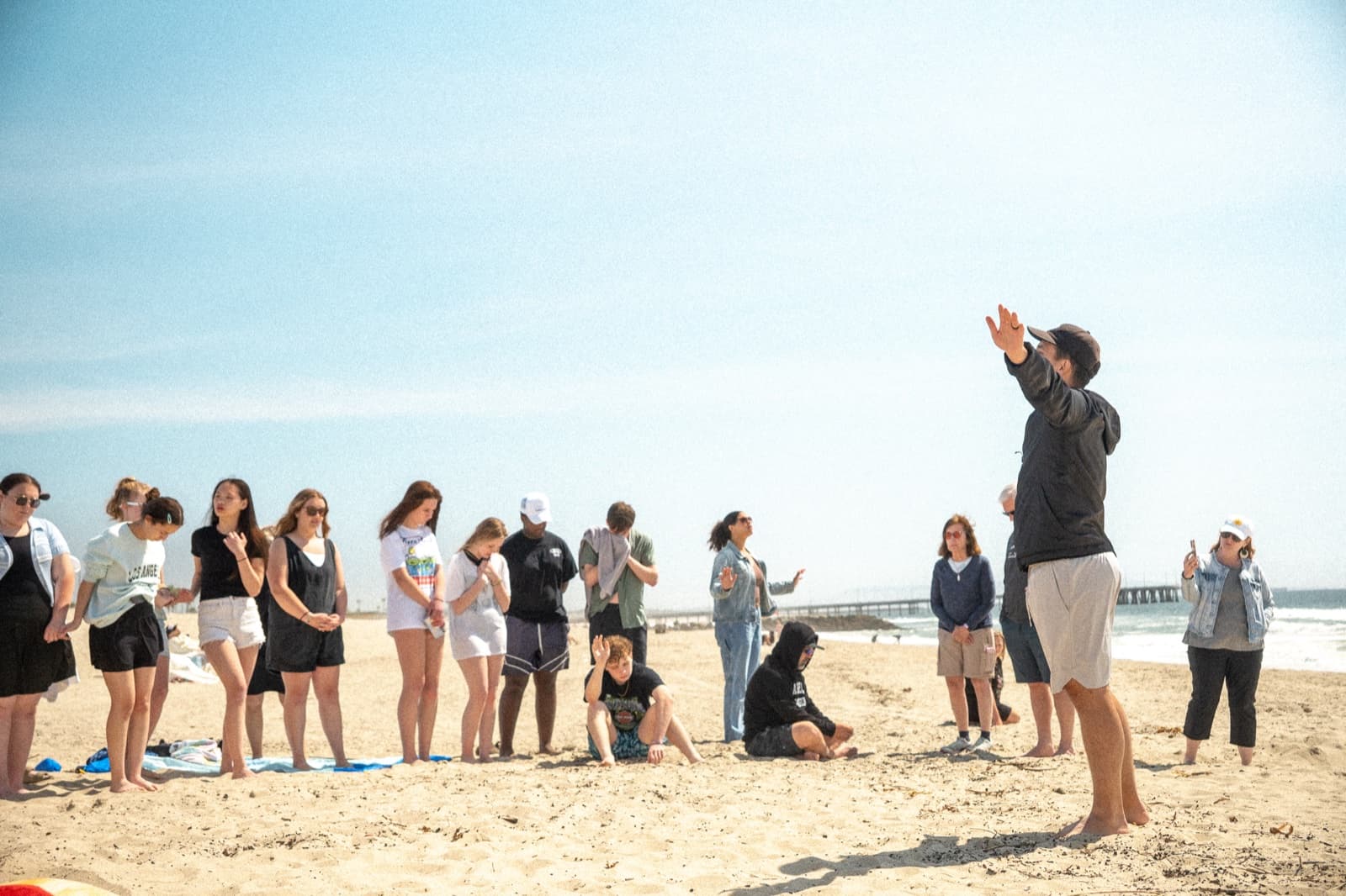 Mission Adventures participants praying together on a Los Angeles beach